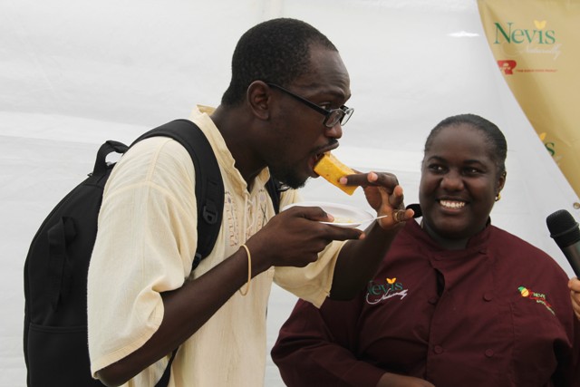 A patron at the Nevisian Chef Mango Feast hosted by the Nevis Tourism Authority on July 10, 2016, at Oualie Beach, samples Chef Berecia Stapleton’s “Drunken Mango Corn Bread” while she looks on in delight
